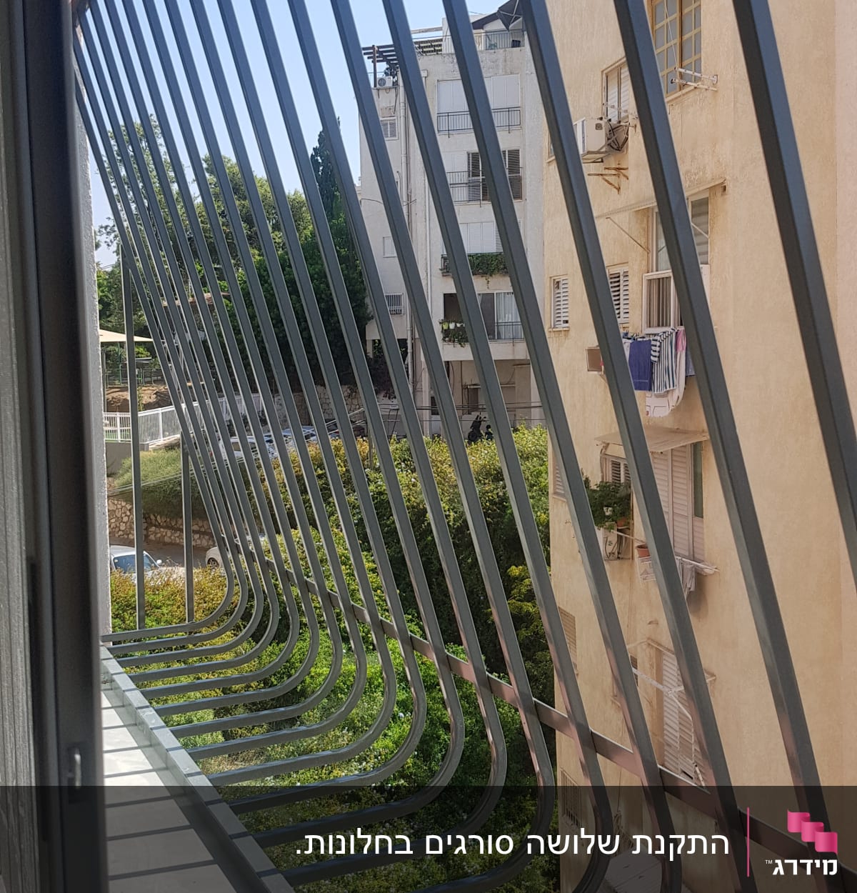 סורגים מתכתיים על מרפסת עם נוף לבניינים
